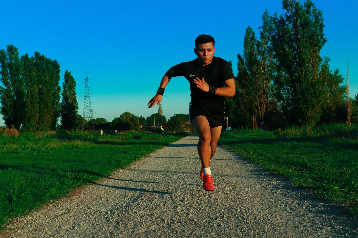 Athlete sprinting outdoors on a gravel path, illustrating cardio fitness training for VO2 max